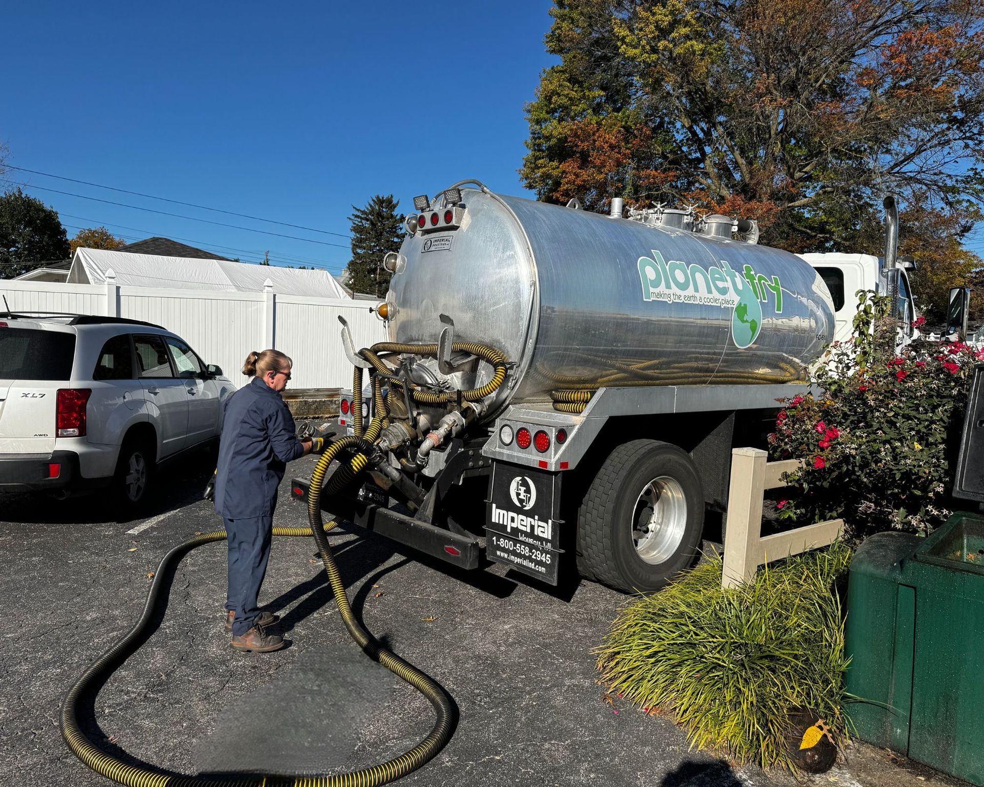 A man is standing in front of a septic tank truck