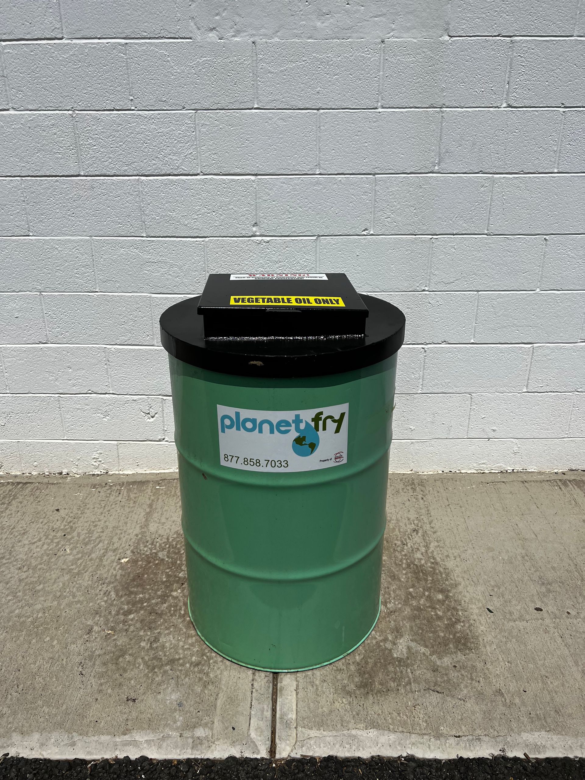 A green barrel with the word planet fry on it