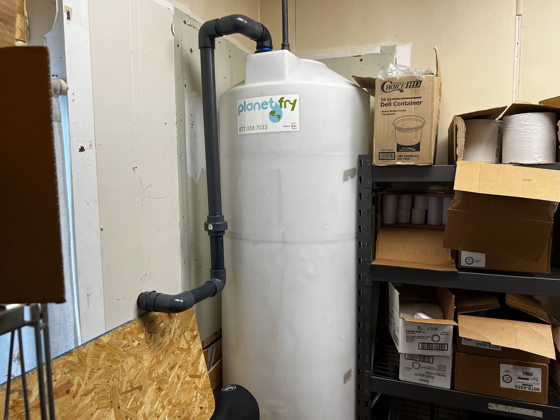A large white tank is sitting in a room next to boxes.