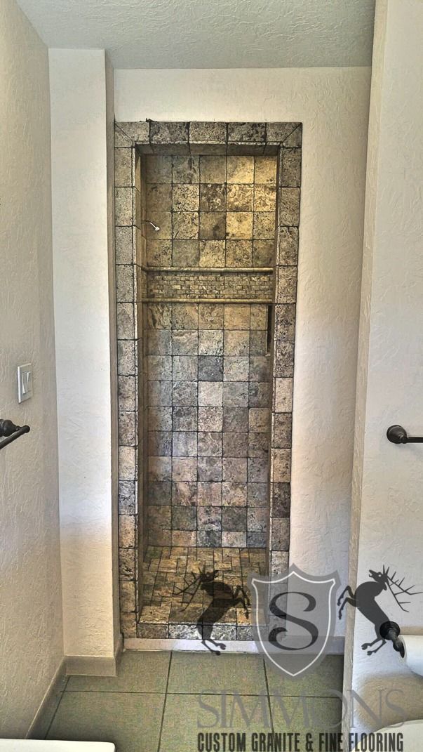 Narrow tiled stone feature wall in a doorway, with beige walls and black handrails on both sides.