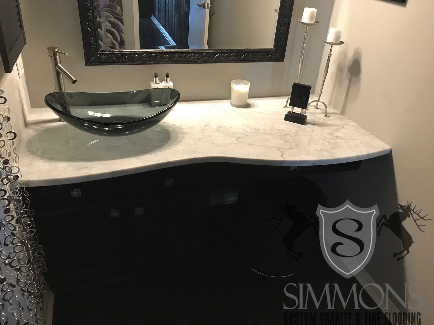 Modern bathroom vanity with black bowl sink, marble countertop, and mirror