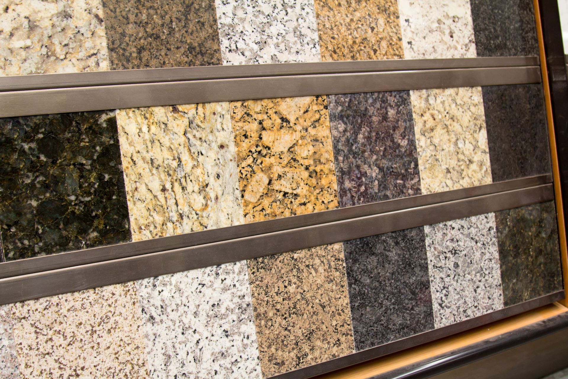 Assorted stone sample slabs in brown, beige, gray, and white on a display rack