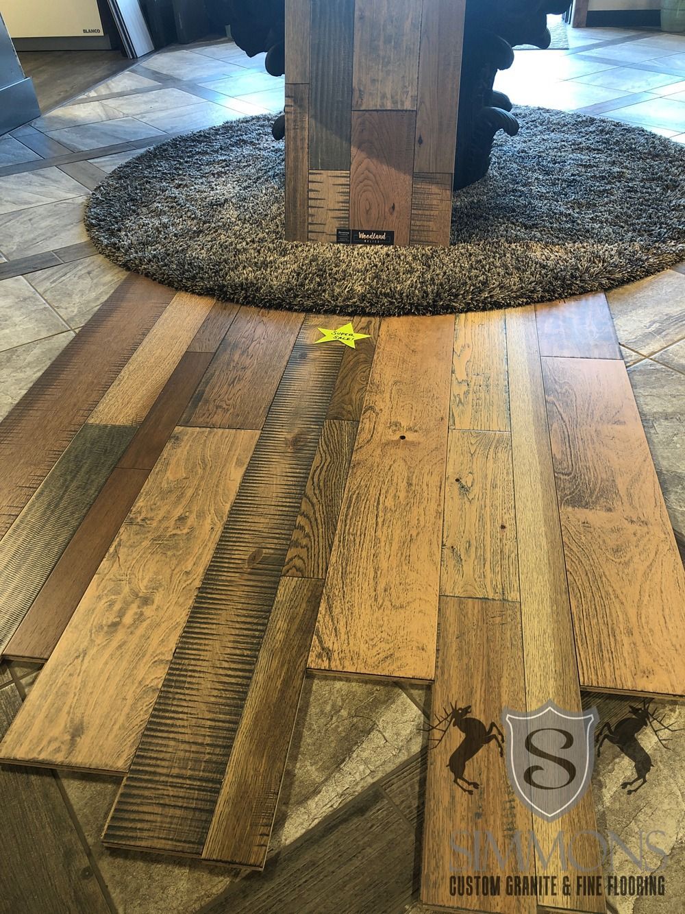 Carpeted walkway with a central tree trunk and a visible floor repair seam in the foreground.