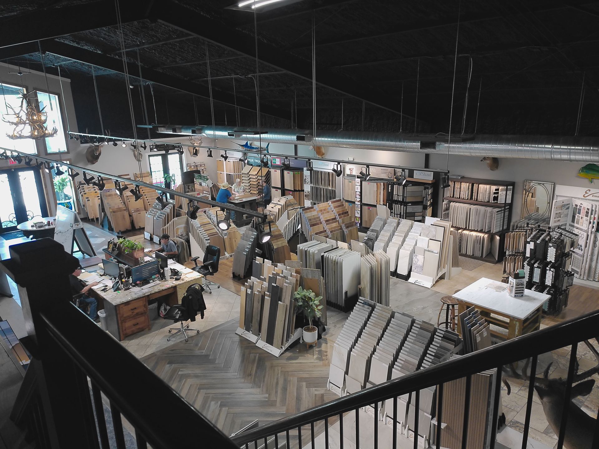 Interior of a furniture and home decor store with shelves, tables, and display pieces visible from an upper balcony