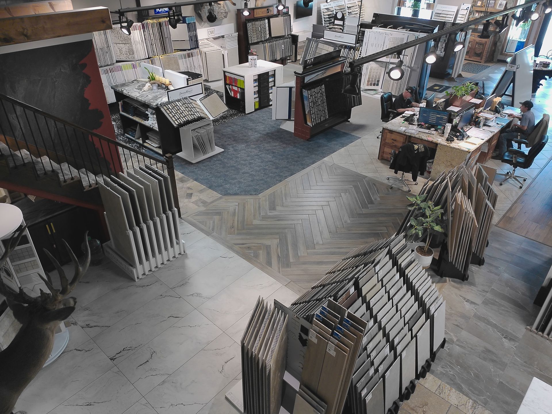Retail flooring showroom with sample displays, tile racks, and product tables