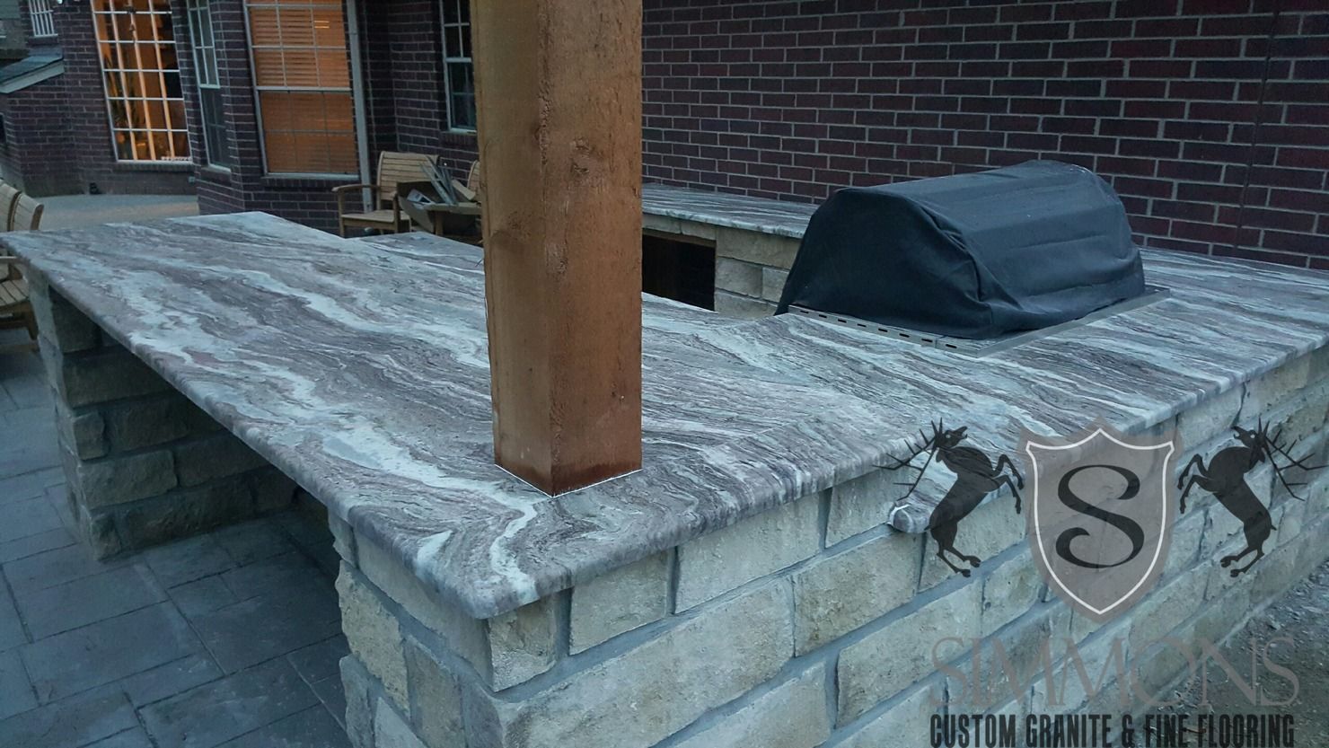 Rooftop with a brick chimney, metal vent cap, and weathered flashing on a flat gray surface
