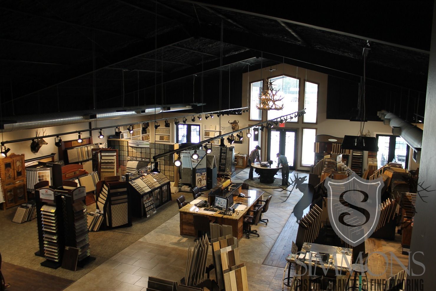 Interior of a rustic gift shop with shelves, tables, and display racks under a high dark ceiling