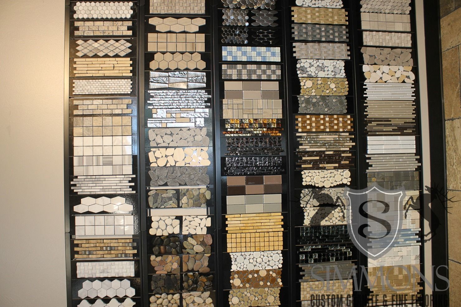 Wall display of assorted decorative trim and molding samples in white, cream, gold, and gray