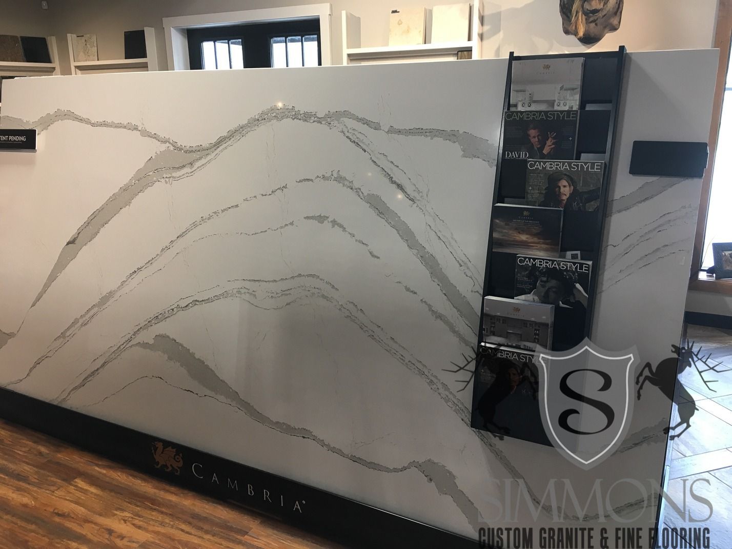 Lobby display with abstract wavy line art and a narrow product shelf on the right