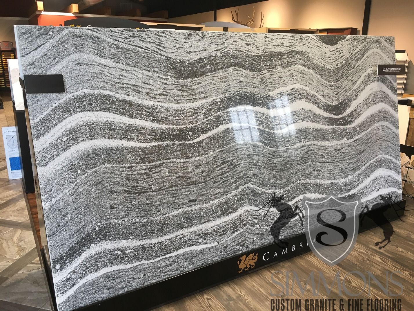 Black-and-white wavy granite slab display in a showroom, with a polished surface and signage.