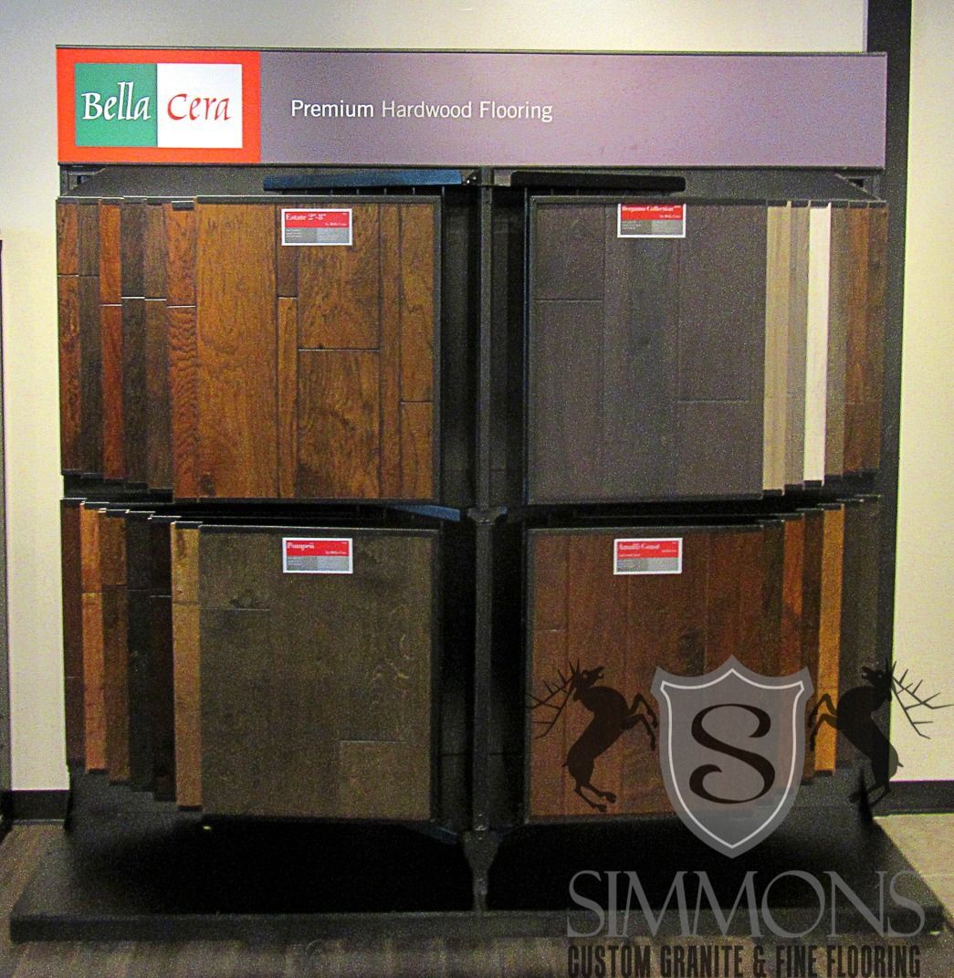 Display of four dark wood and gray recliners in a showroom, with Simmons branding at the bottom.