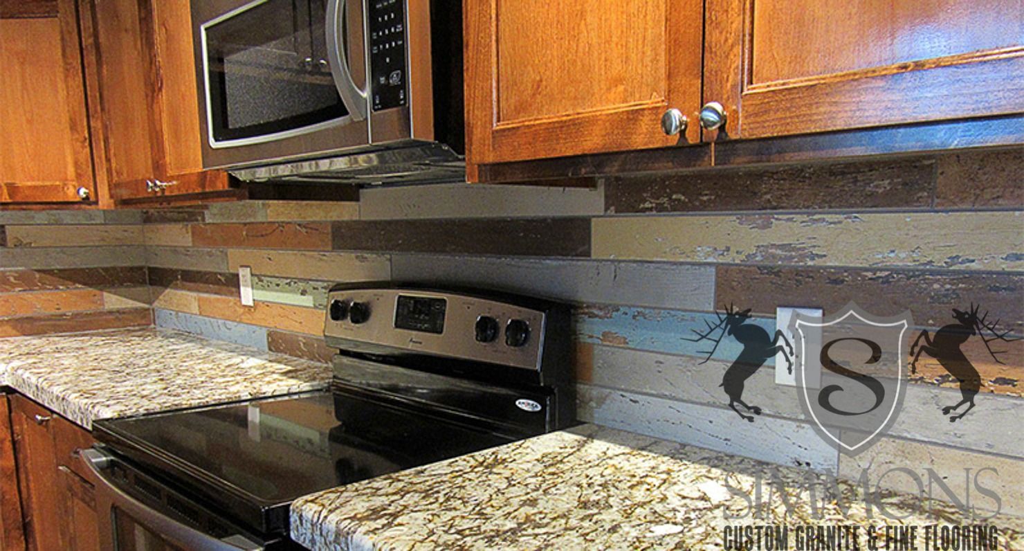 Kitchen with wooden cabinets, stainless microwave and stove, granite countertops, and a decorative tile backsplash.