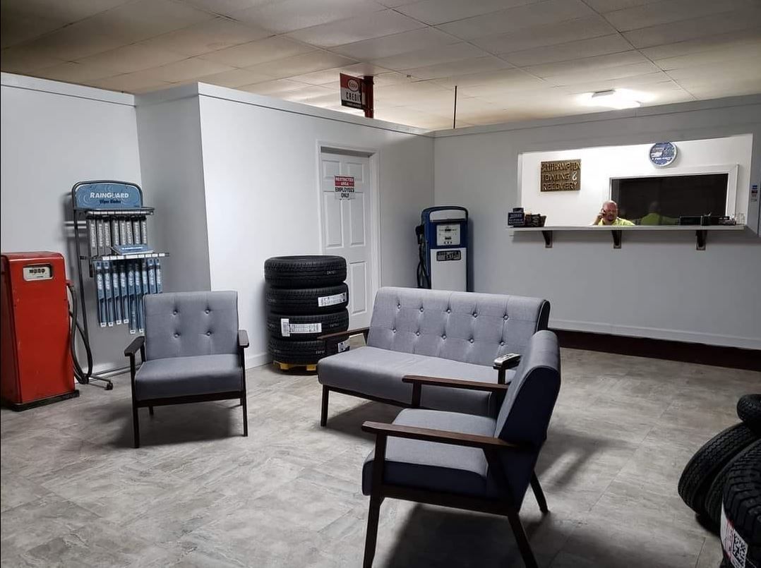 Waiting room with gray furniture, tires, and retro gas pump.