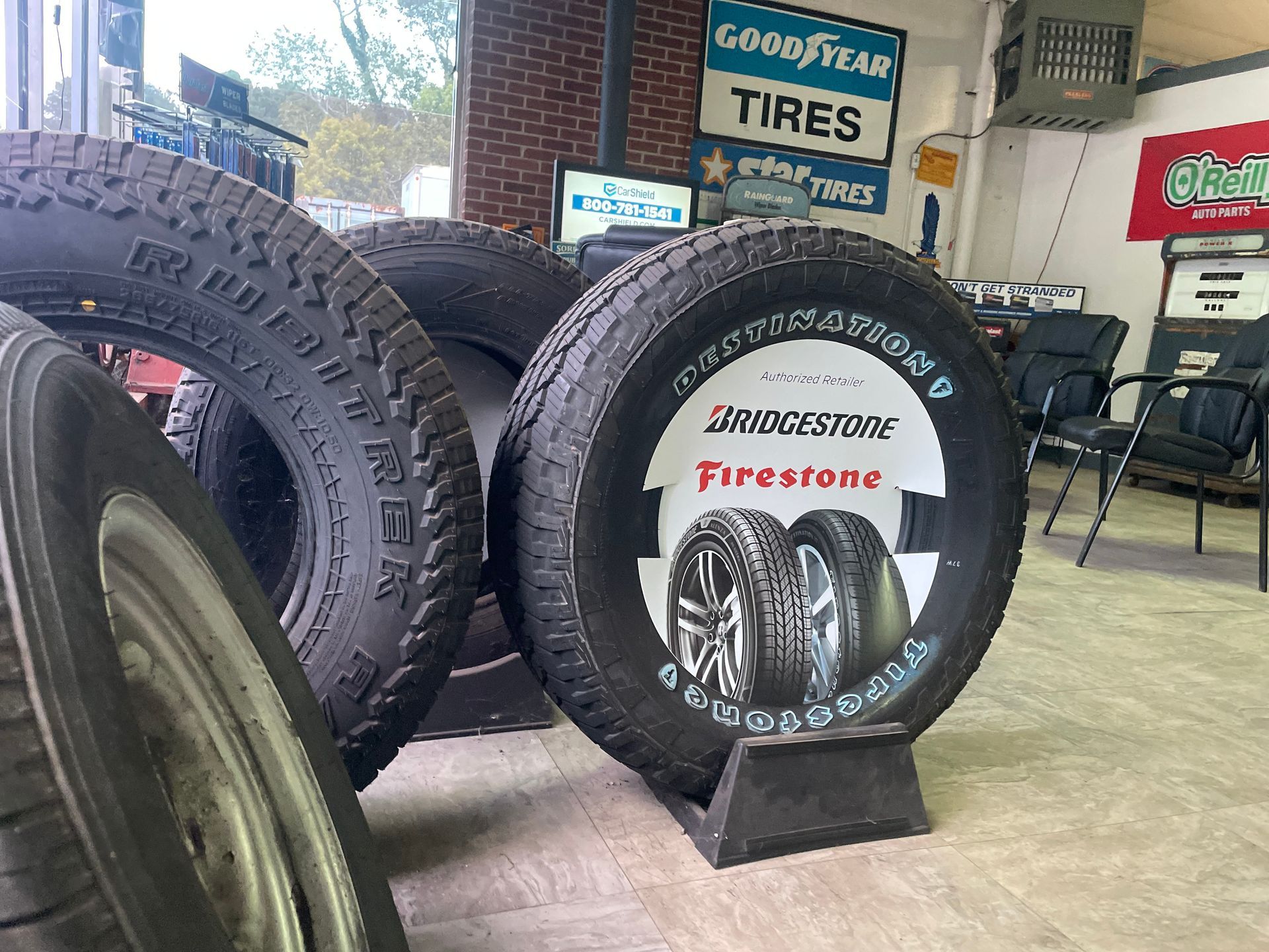 Tires displayed inside a tire shop, with Bridgestone Firestone advertisement.