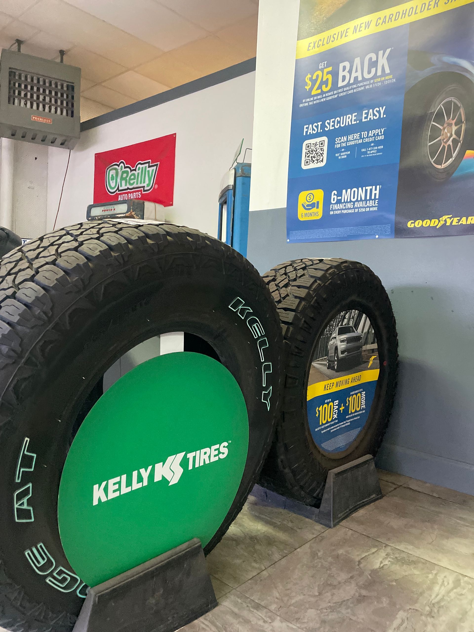 Two tires on display, branded Kelly Edge Tires, in an auto shop.