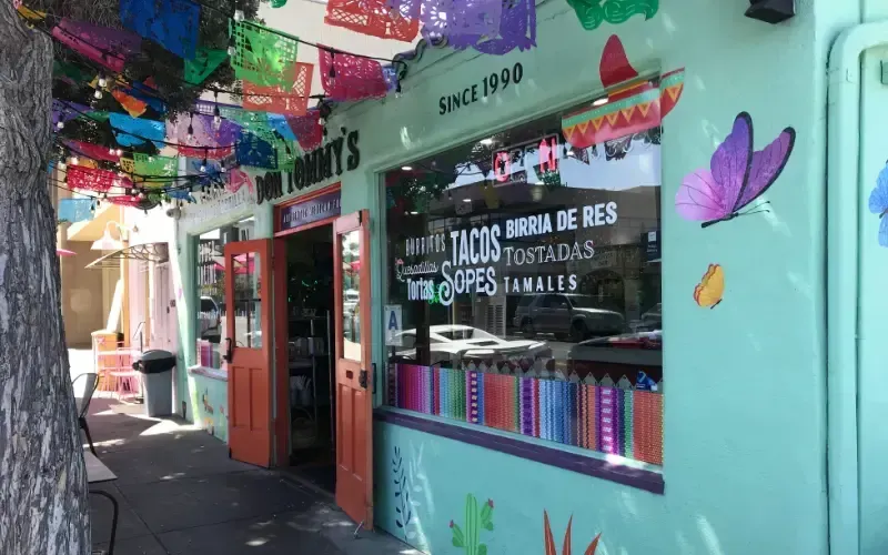 Colorful storefront with books and souvenirs under hanging decorations in a narrow market alley