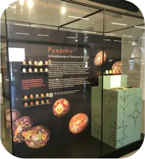 Museum display about pysanky with decorated Ukrainian Easter eggs and a green exhibit pedestal.