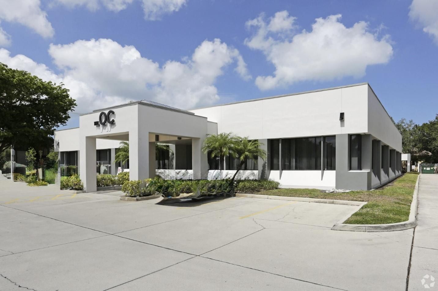 Office building with gray and white facade under a blue sky, 