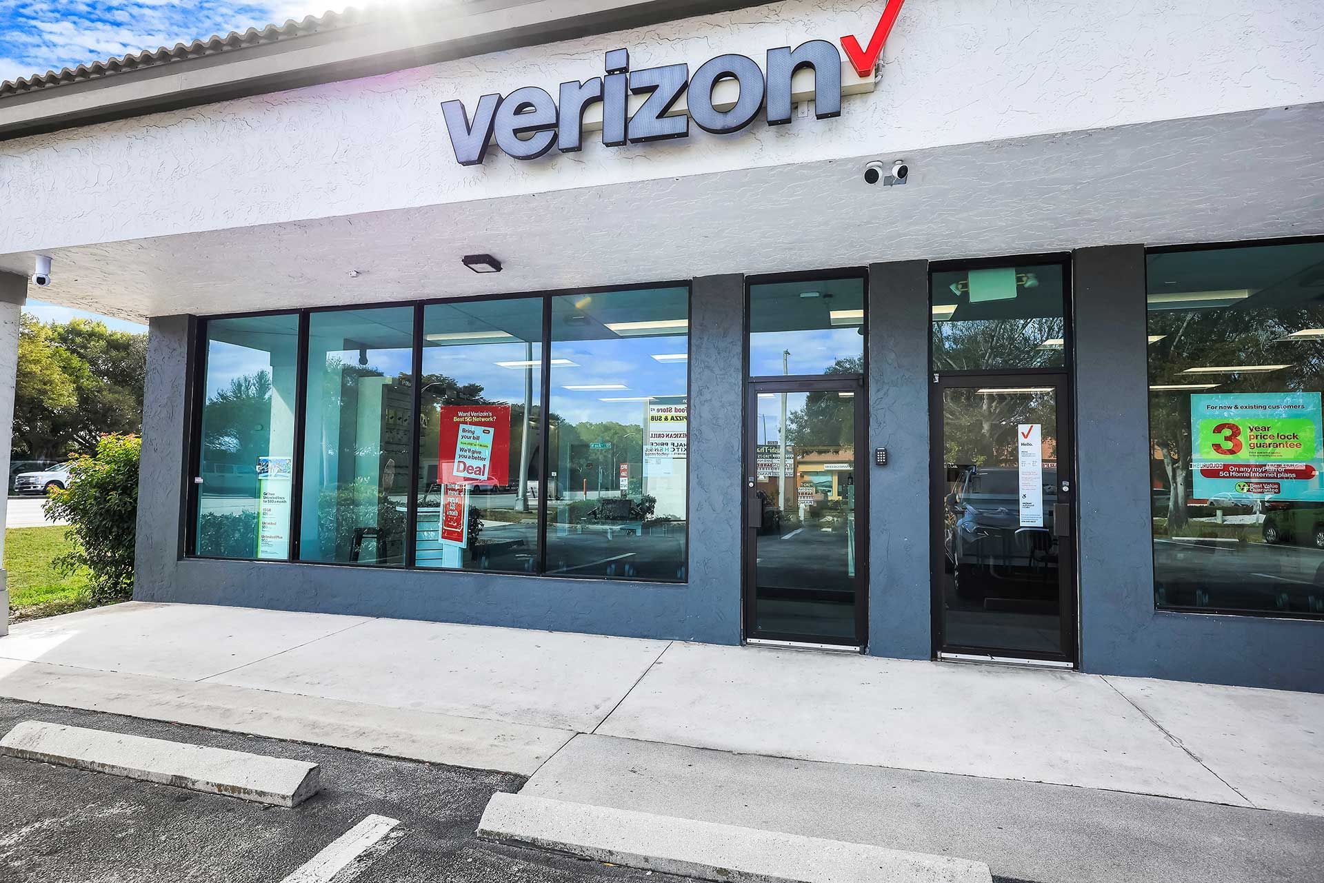 Verizon store exterior with large windows and sign, gray and white facade.