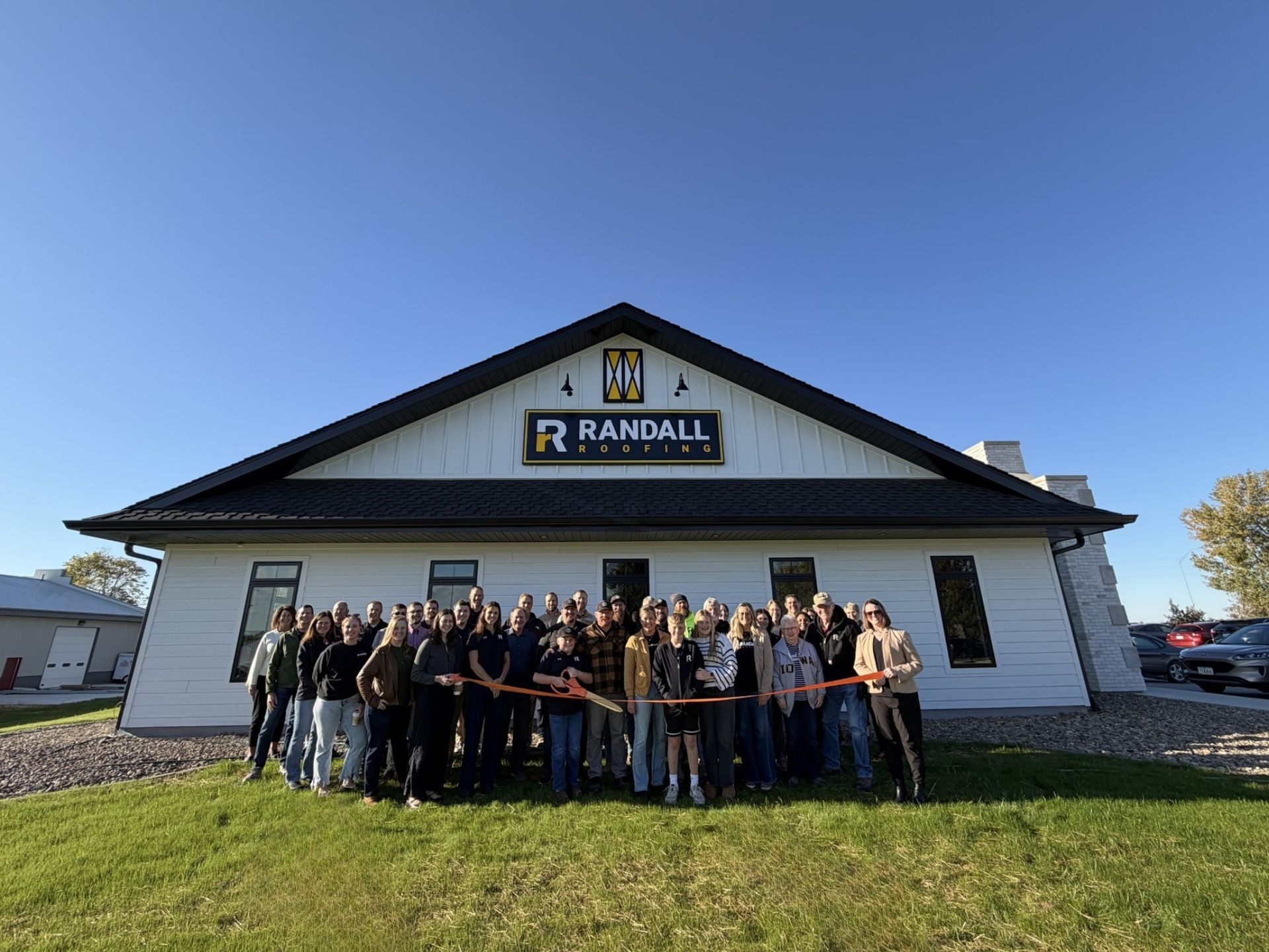 A group of people standing in front of a white building with a 