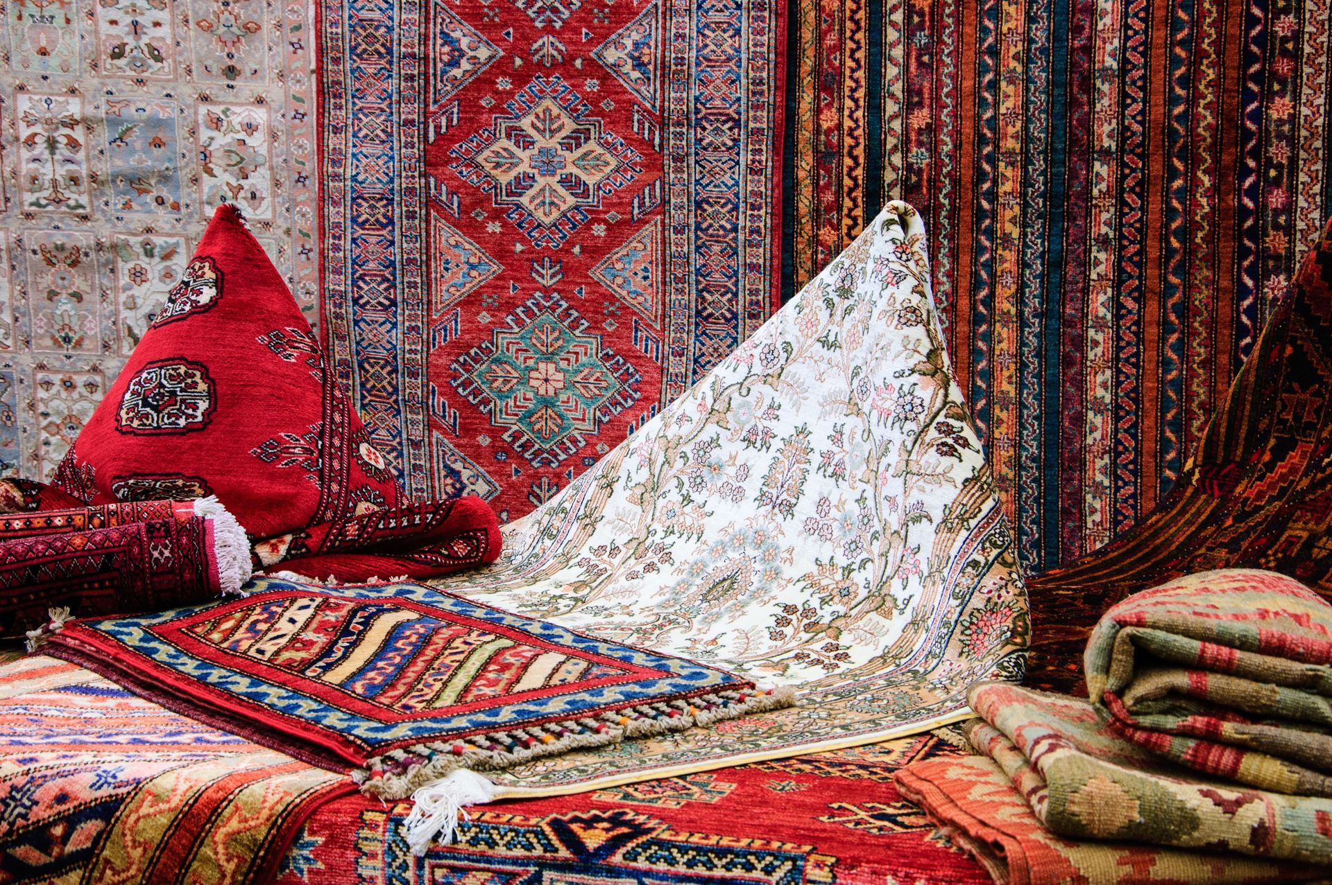 Colorful patterned rugs and carpets are displayed.