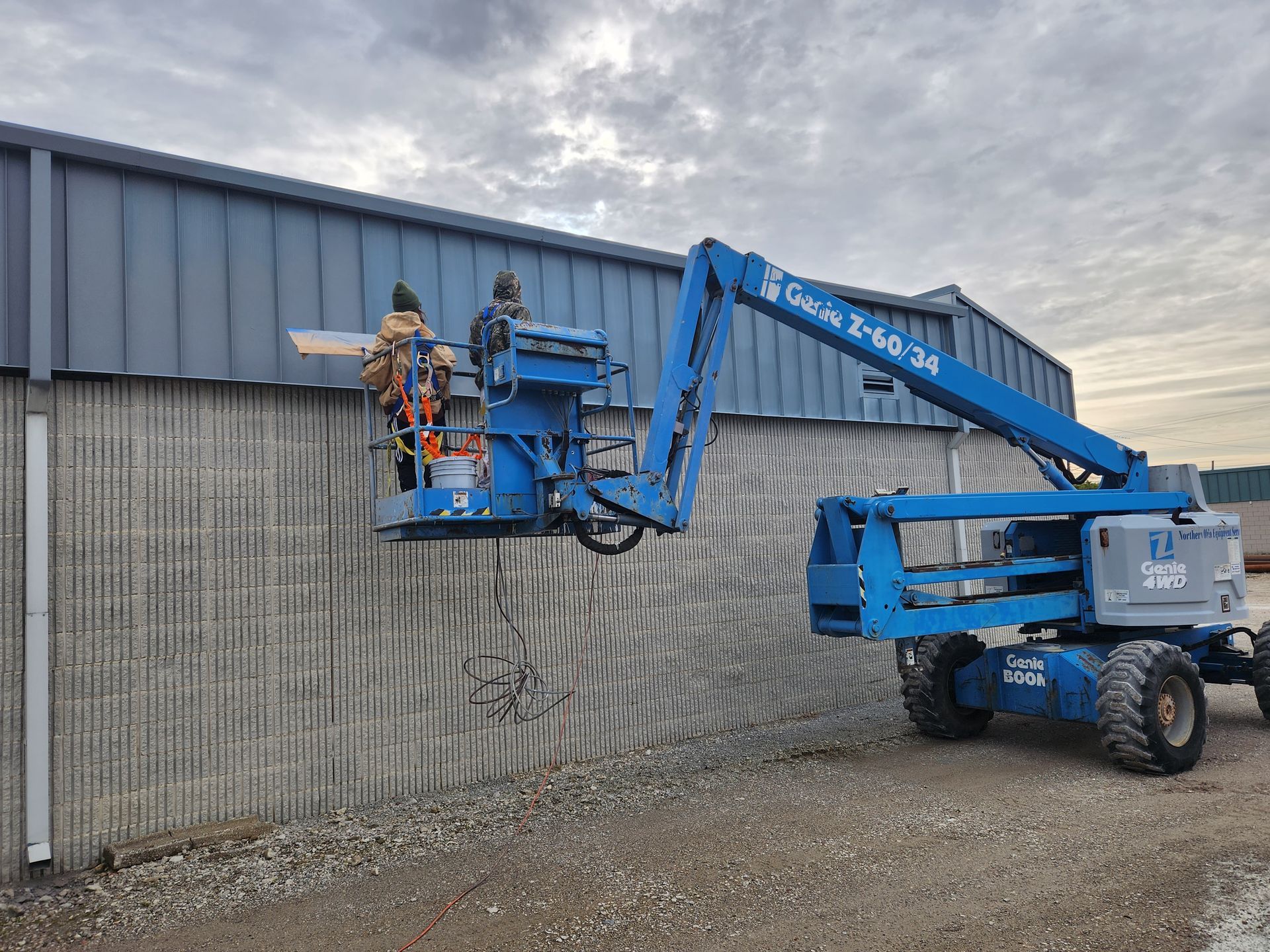 A man is working on the side of a building with a crane.