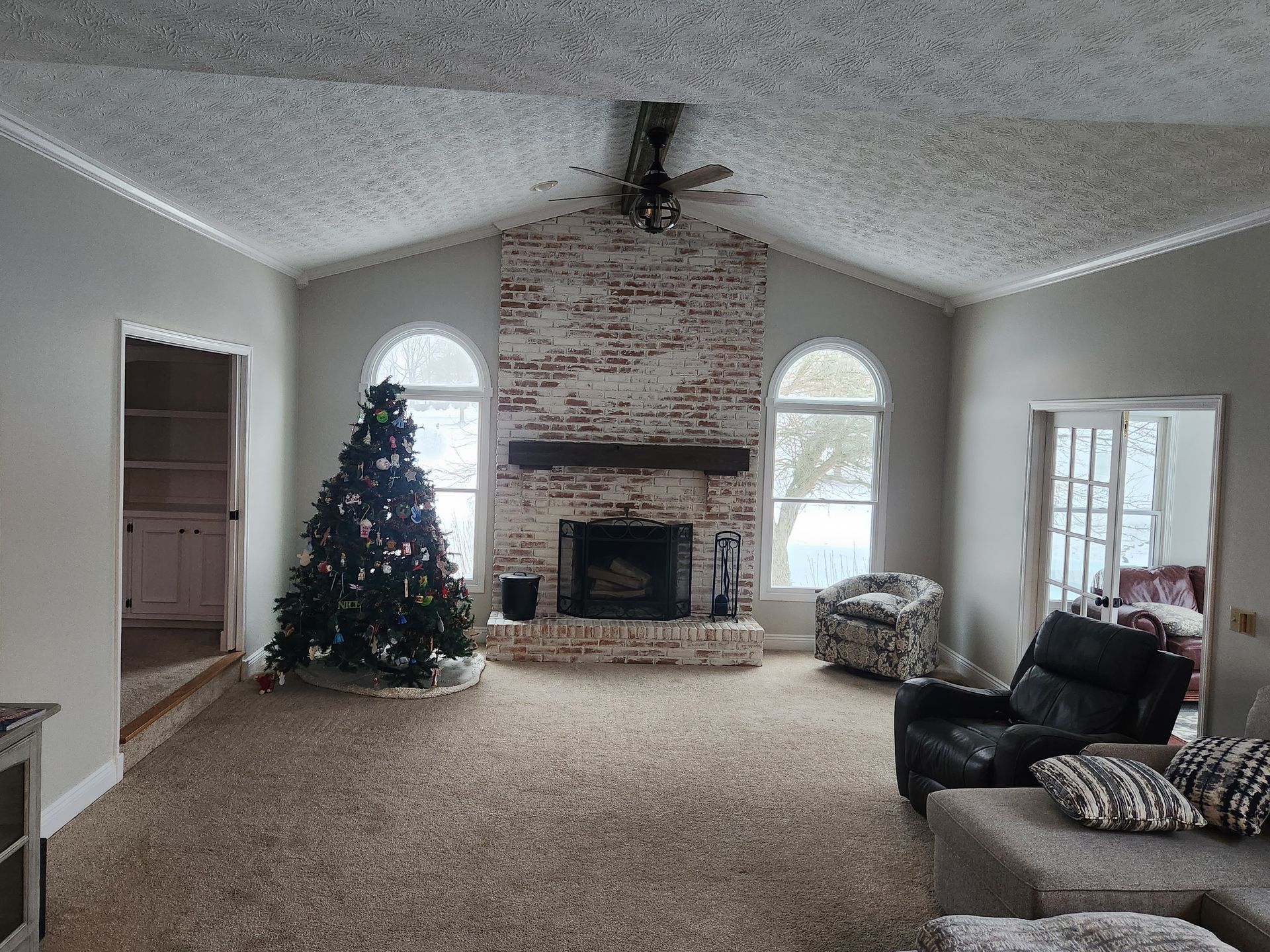 A living room with a fireplace and a christmas tree
