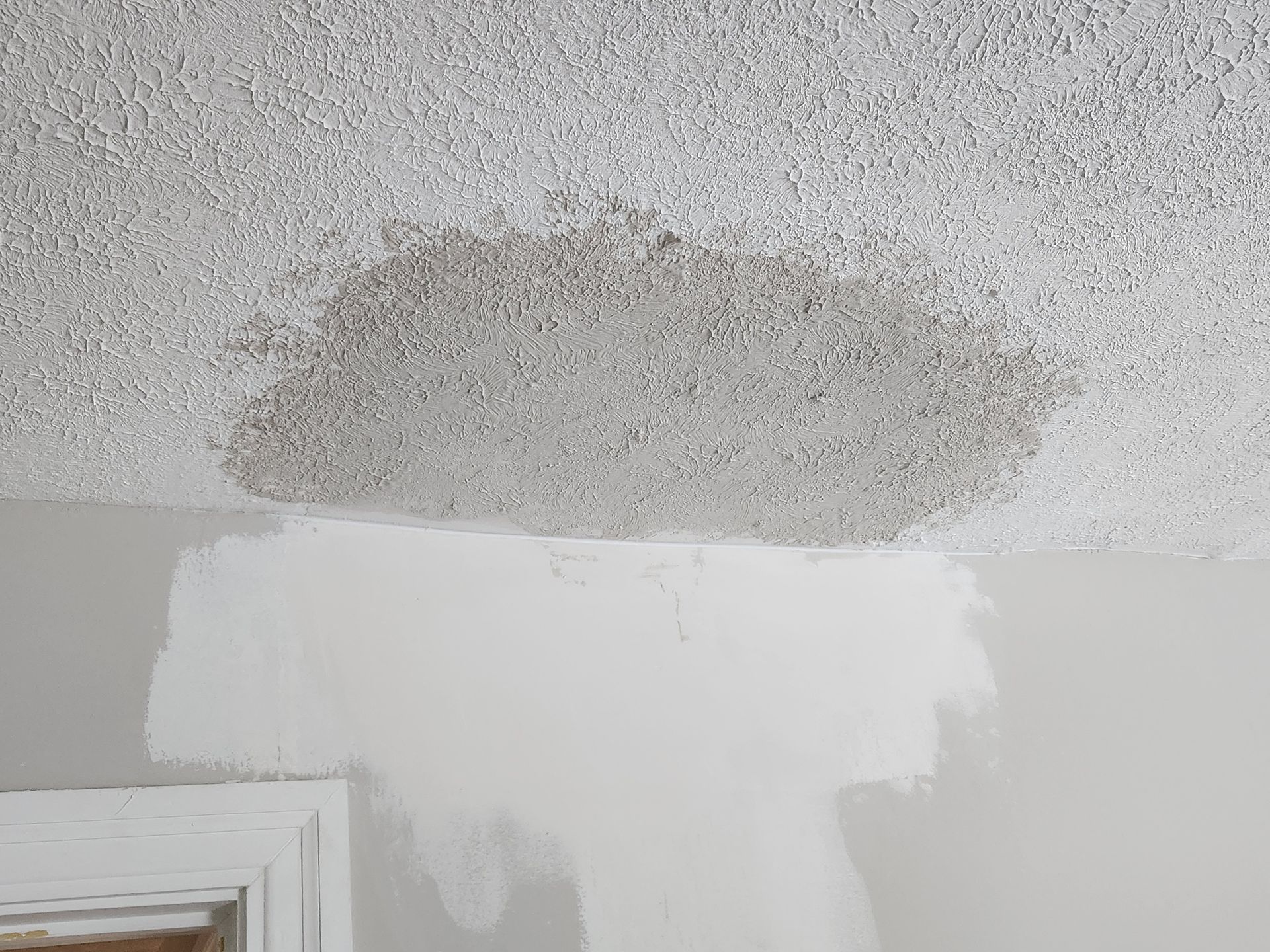 A room with a ceiling that has a stain on it.