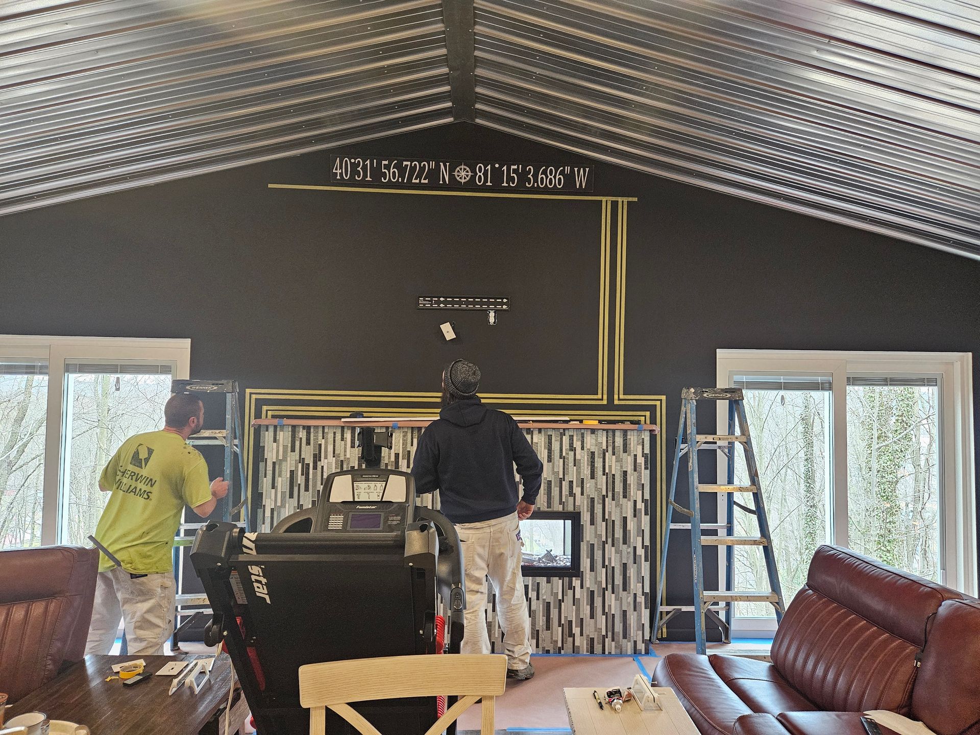 Two men are working on a fireplace in a living room