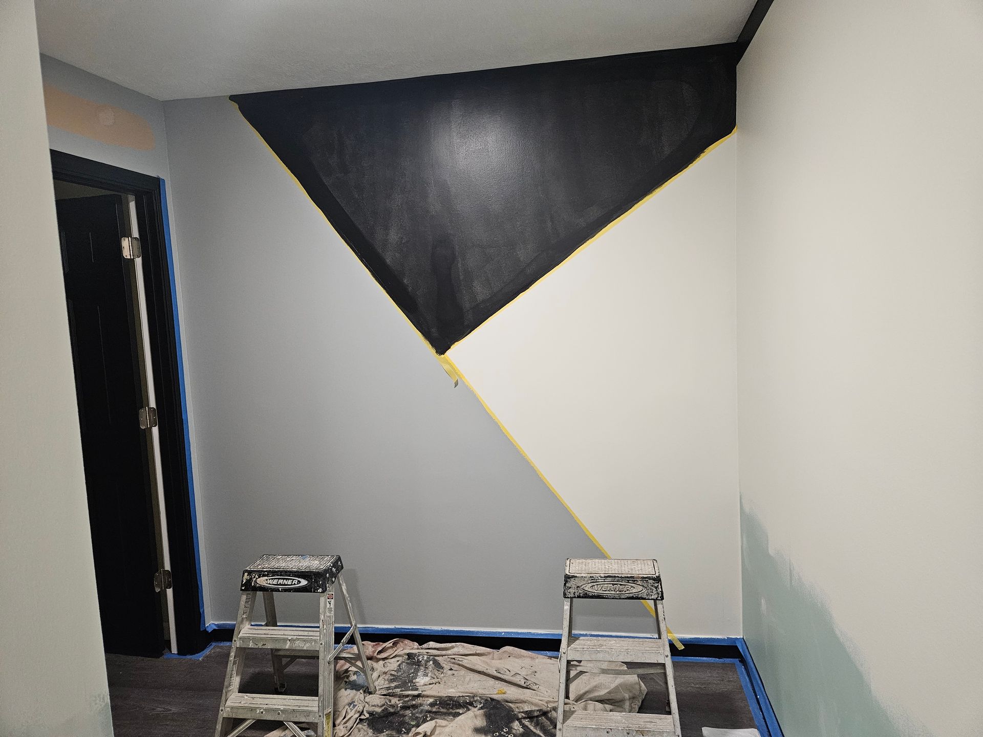 A room that is being painted with a triangle on the wall