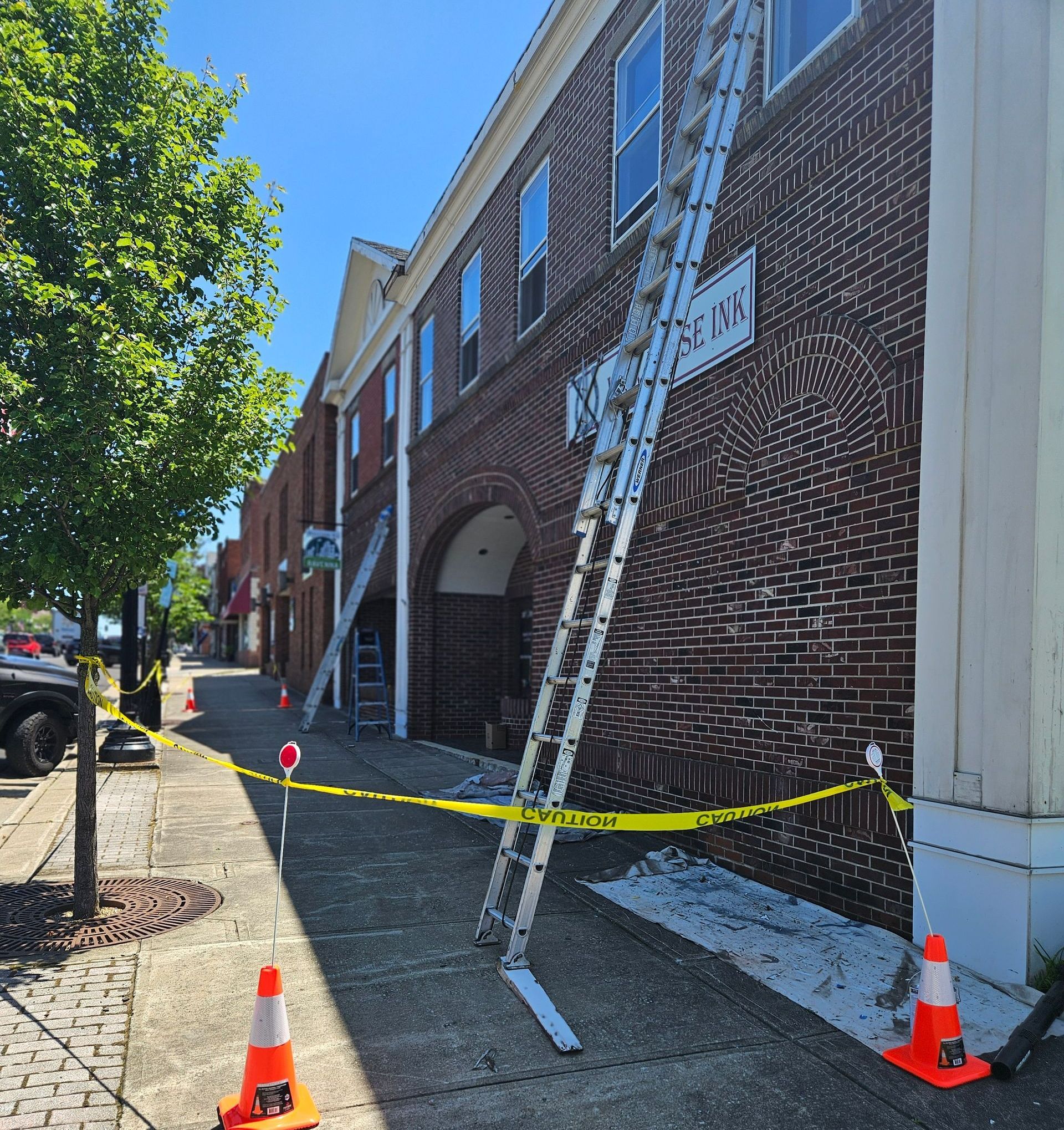 A ladder is leaning against a brick building with a sign that says police