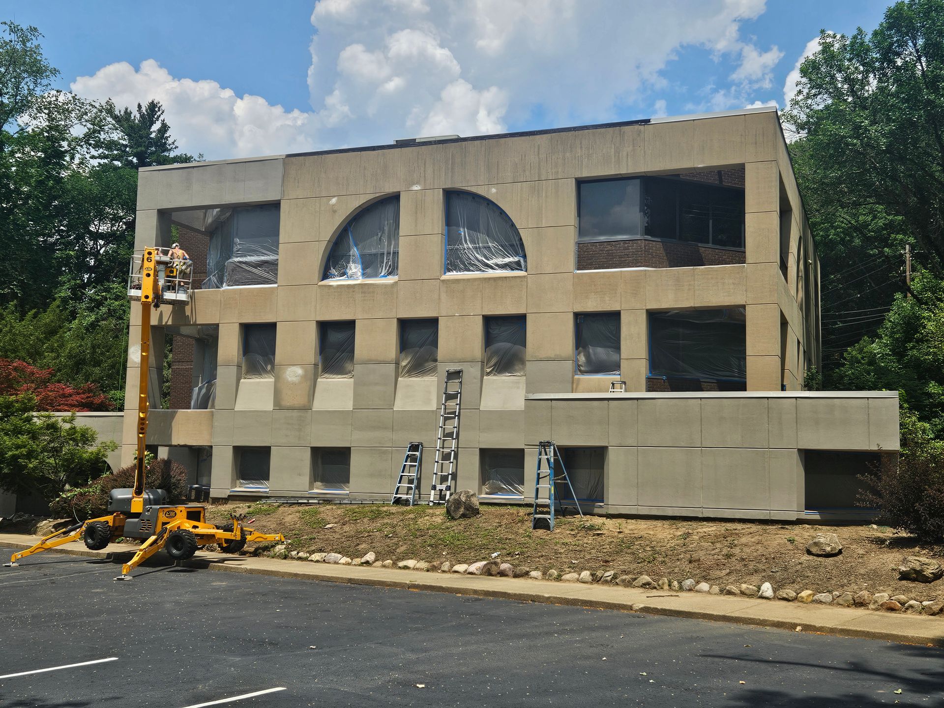 A large building with a lot of windows is being painted