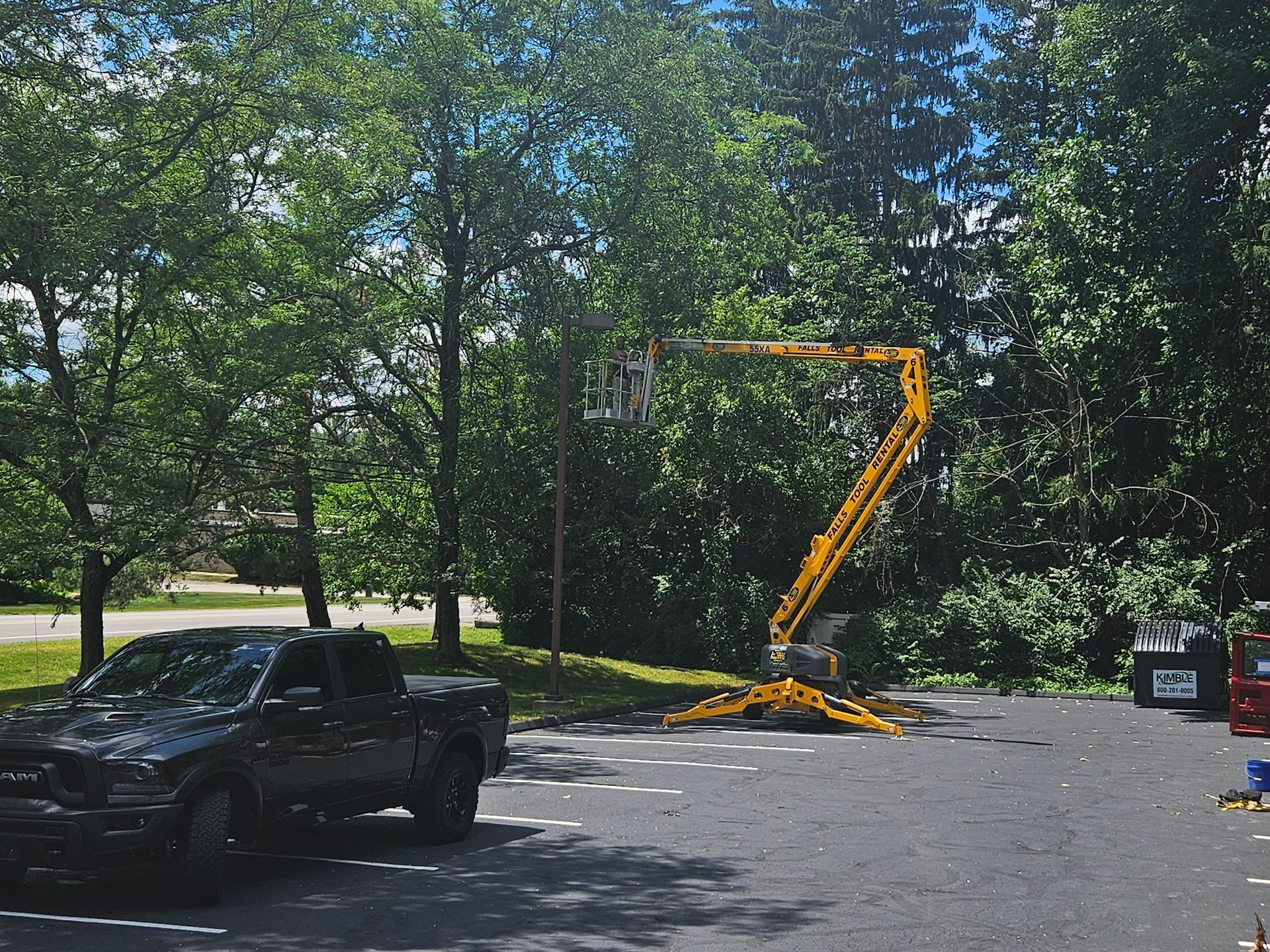 A truck is parked in a parking lot next to a crane