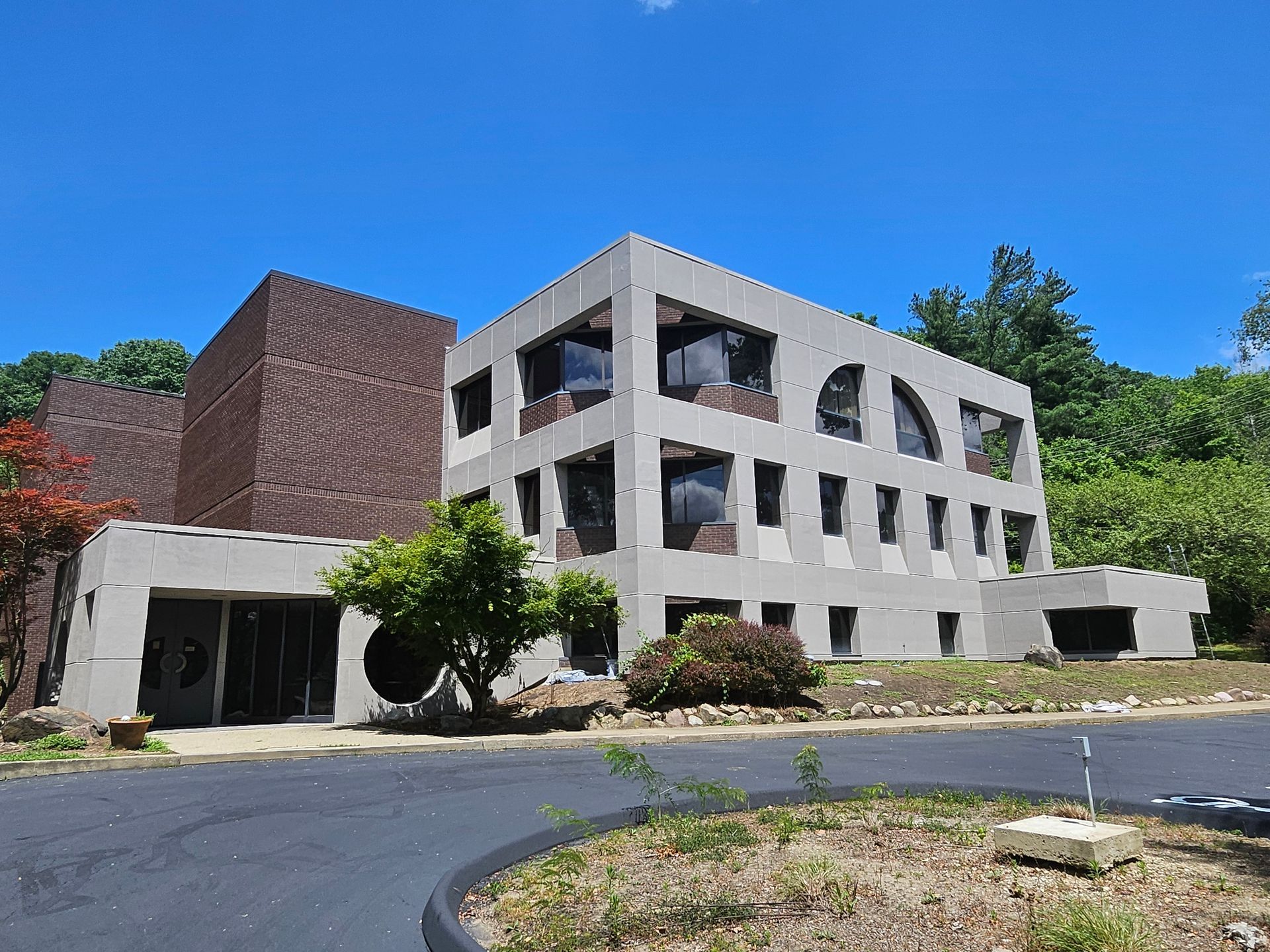 A large building with a lot of windows and trees in front of it.
