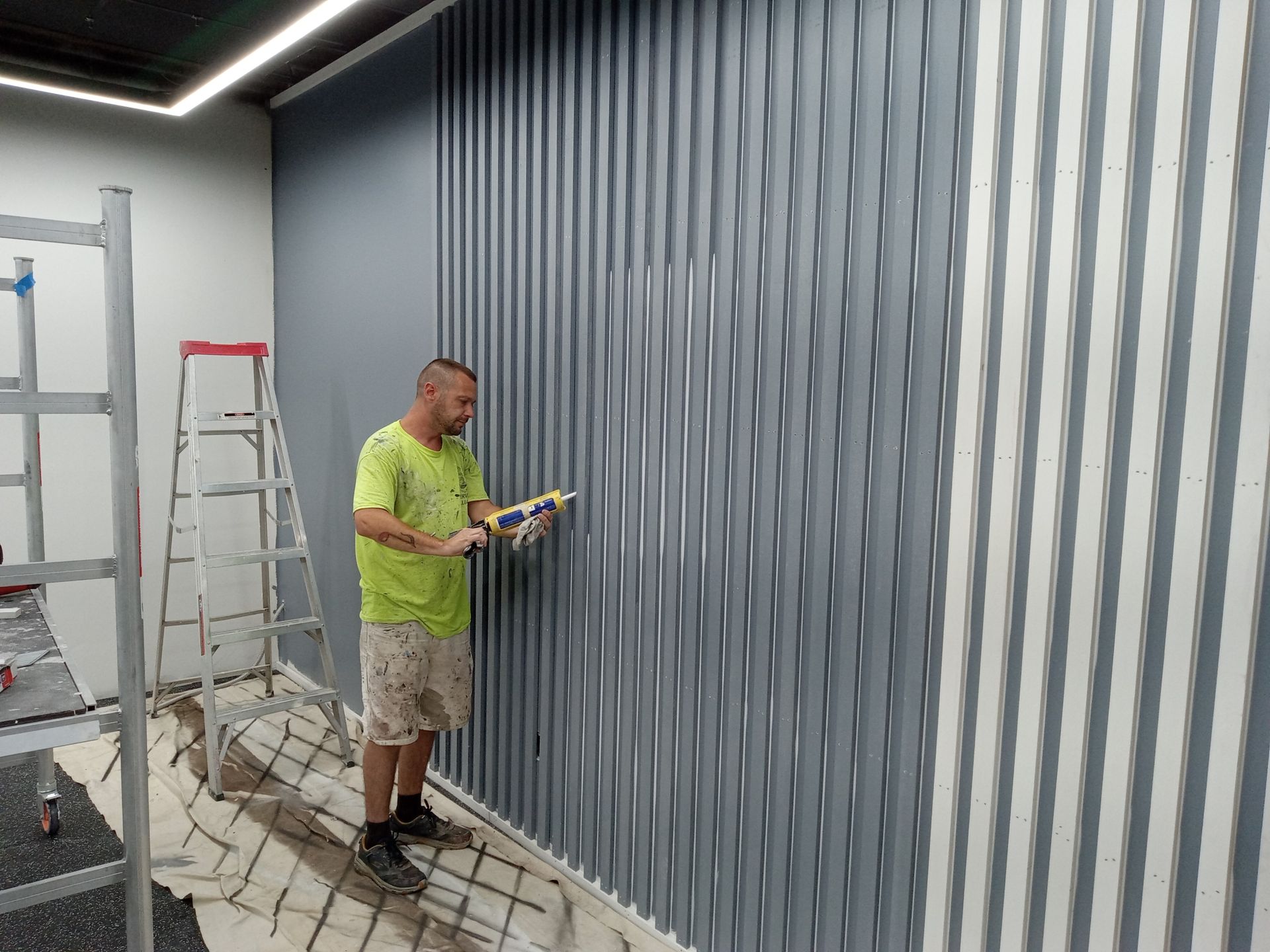 A man is painting a wall with a brush.
