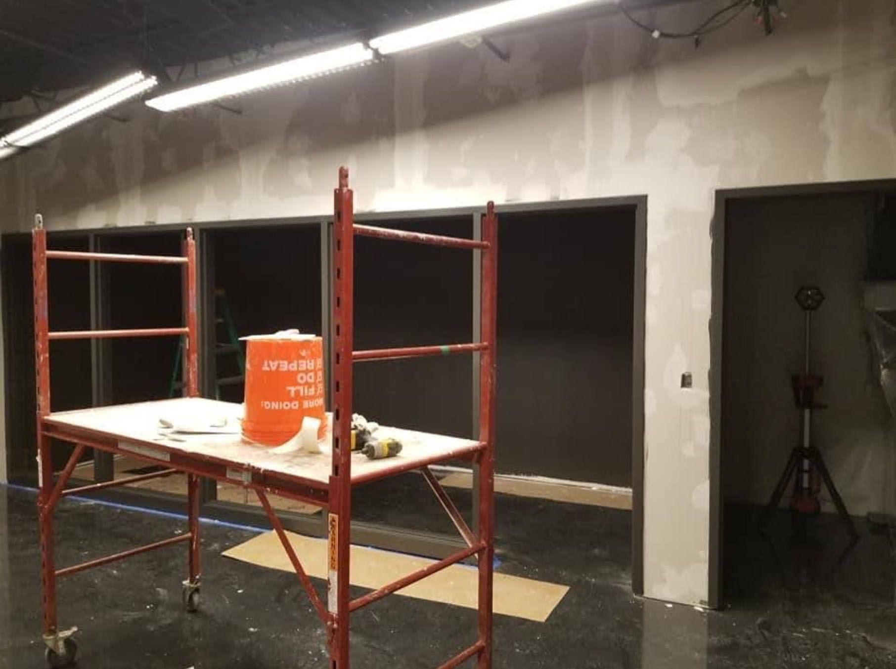 A red scaffolding with an orange bucket on top of it