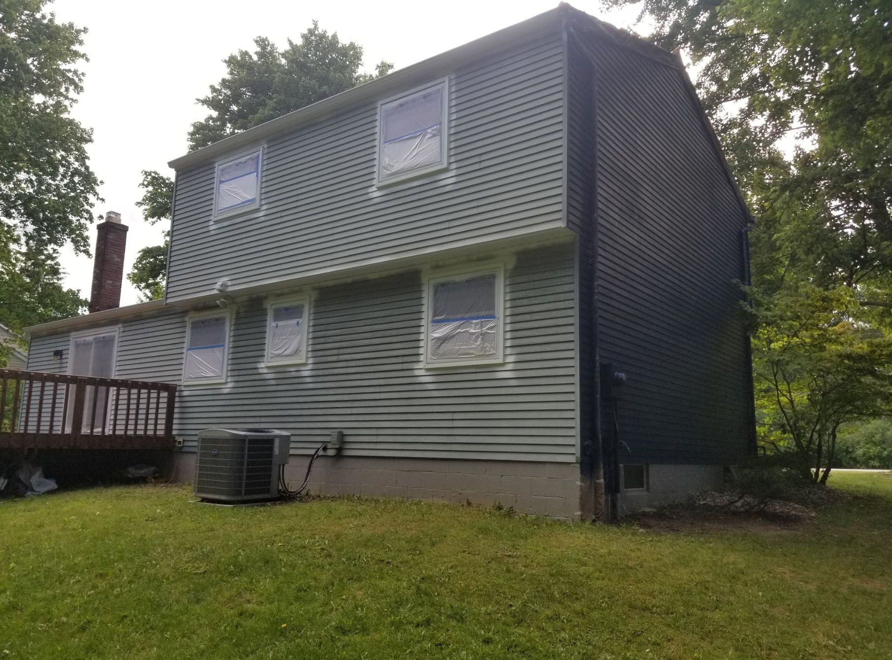 A large house with a lot of windows and a deck in the backyard.
