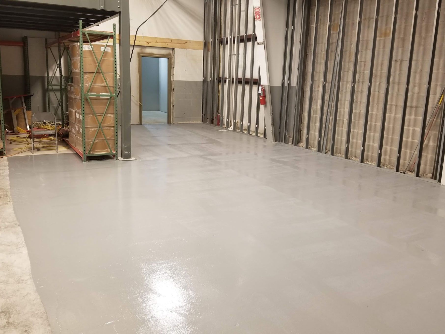 A large warehouse with a concrete floor and a stack of cardboard boxes.