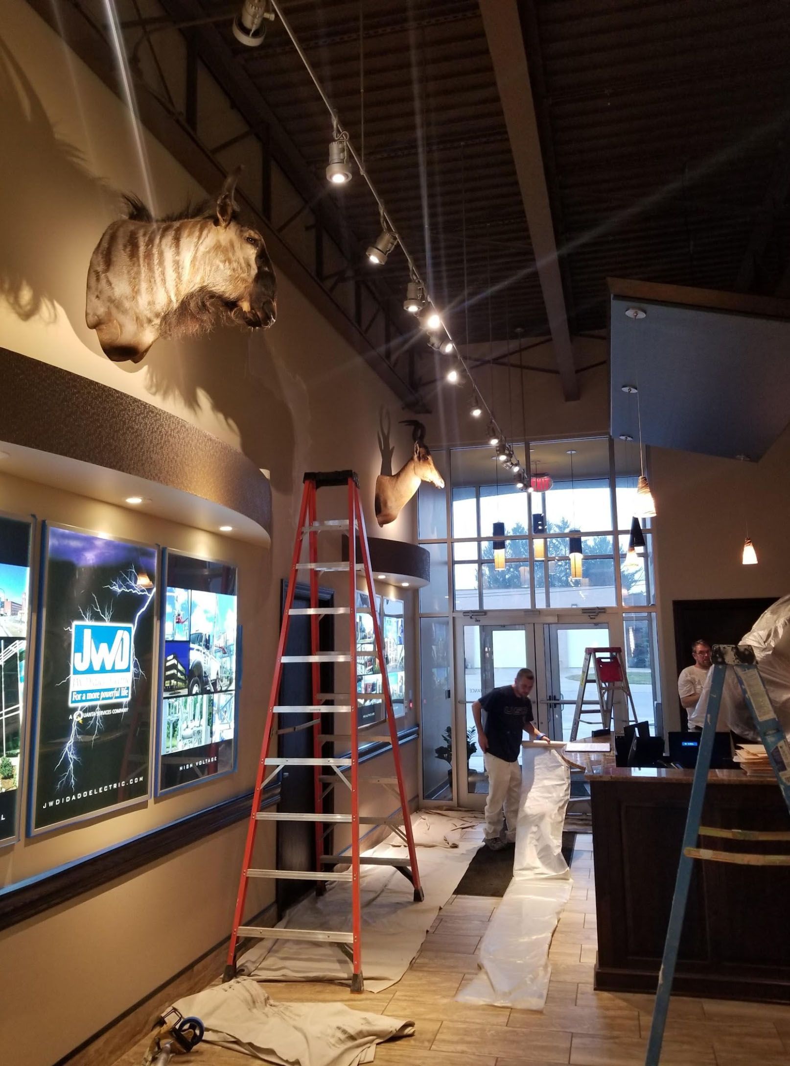 A room with a ladder and stuffed animals on the wall