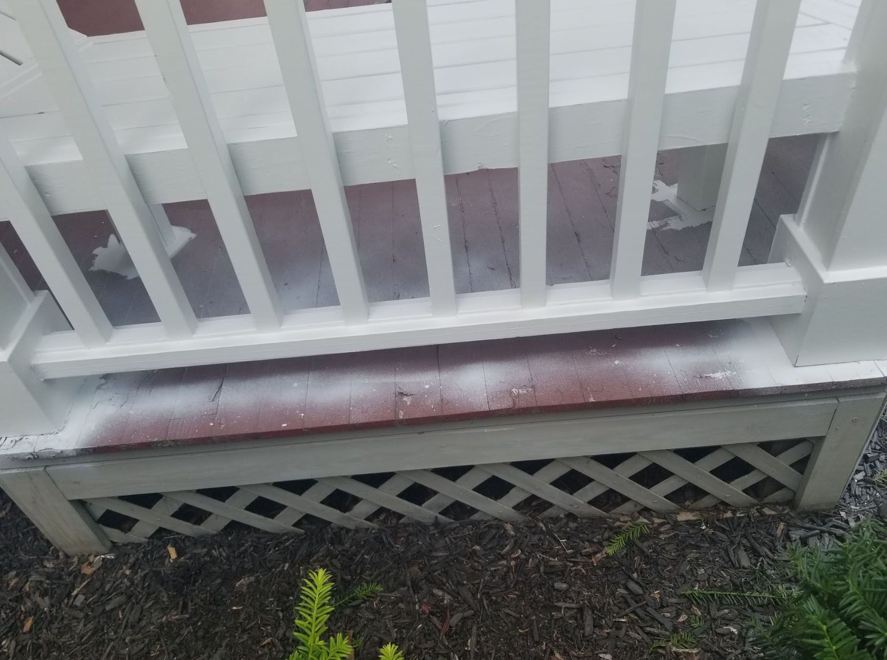 A white railing is sitting on top of a wooden deck.