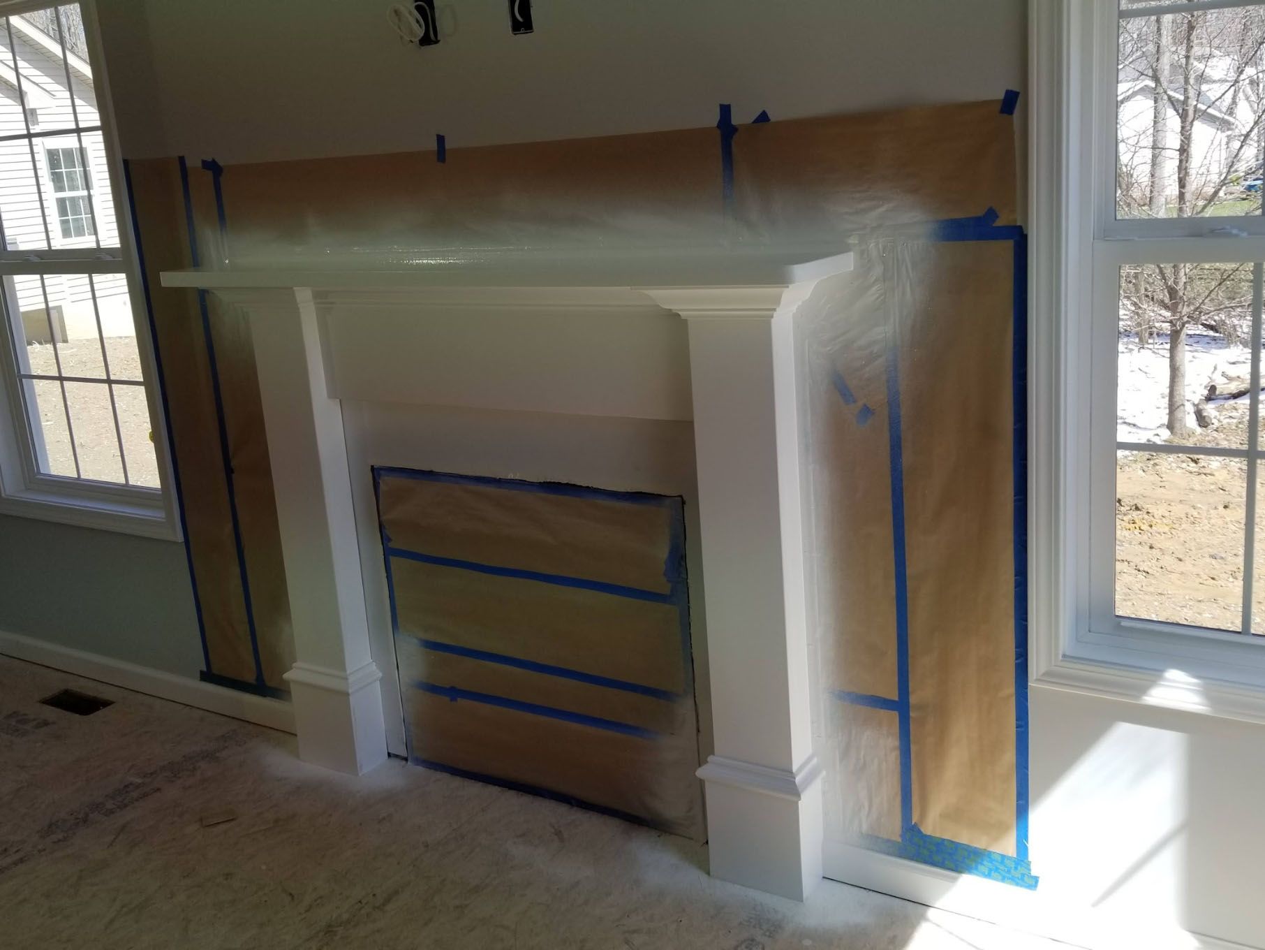 A fireplace is being painted in a living room