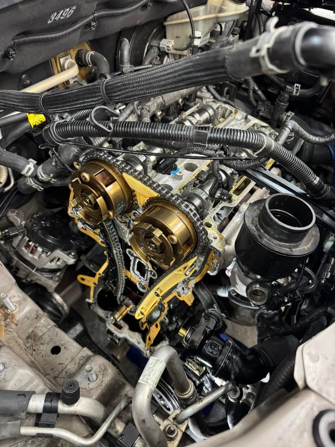 A close up of a car engine with a chain missing.