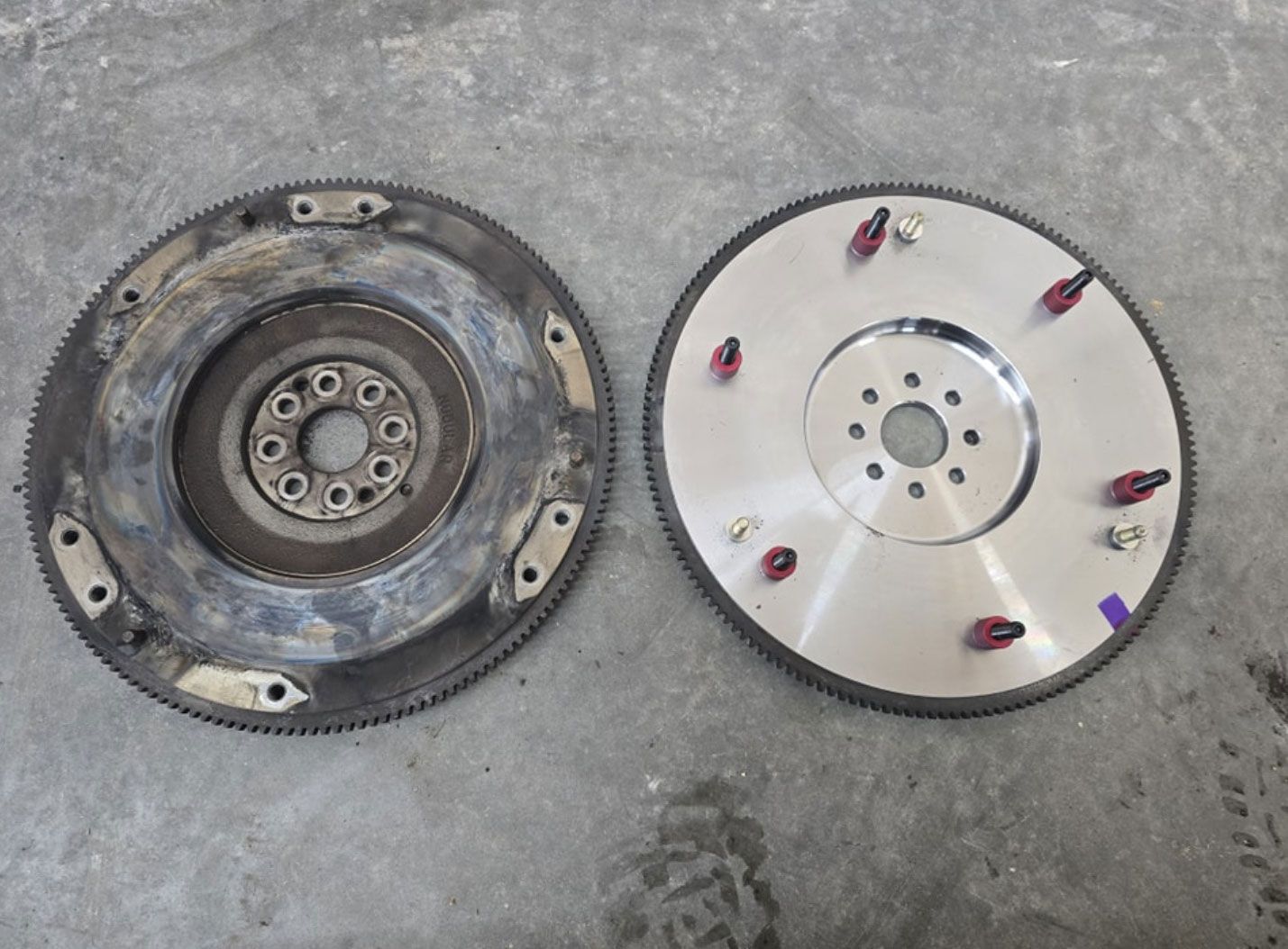 Two clutch discs are sitting on a concrete surface