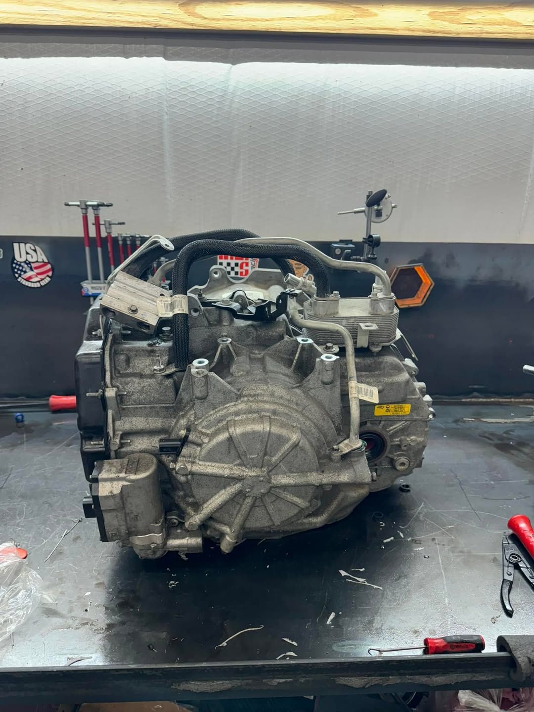 A car engine is sitting on a table in a garage.