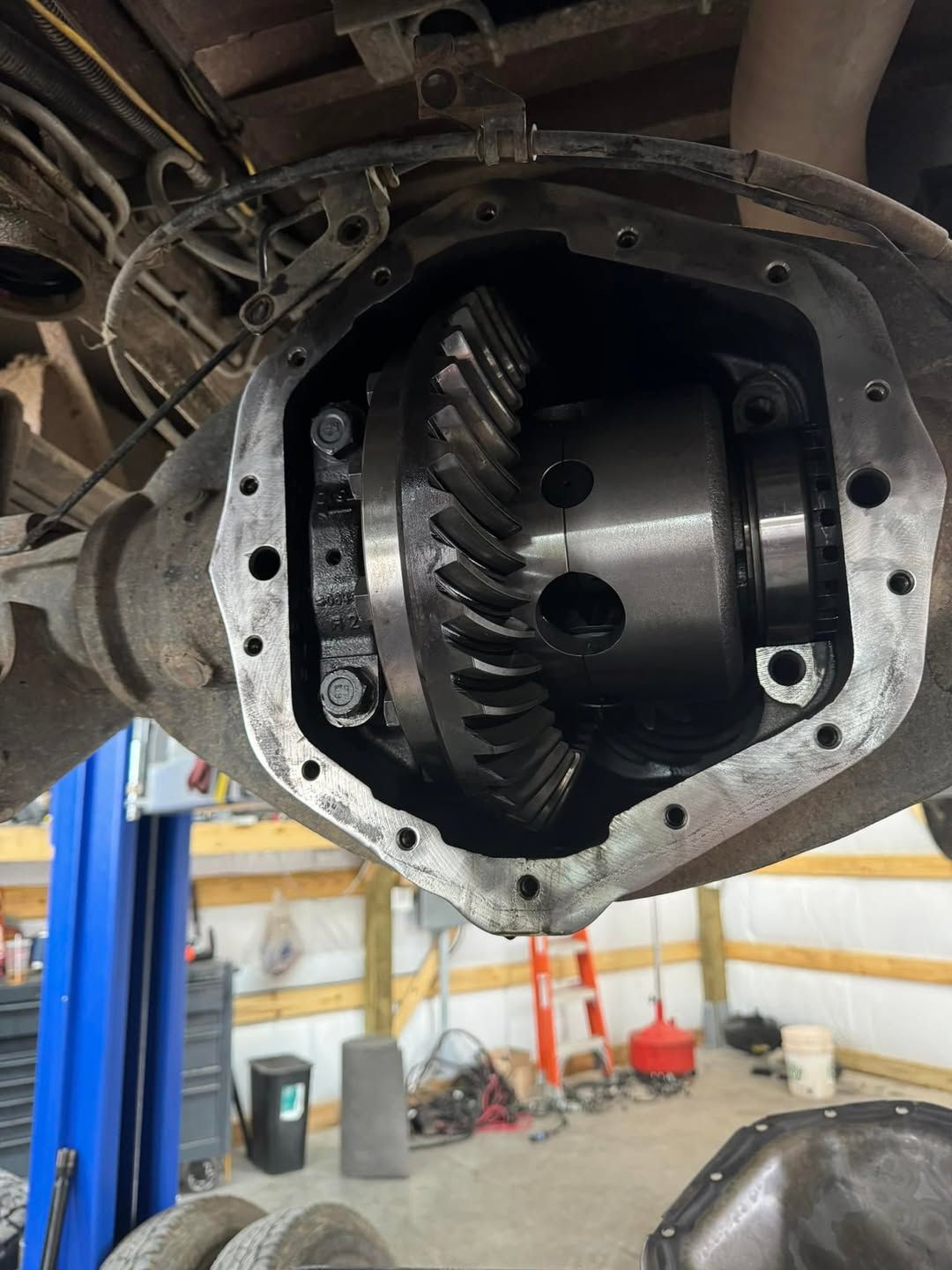 A close up of a rear differential on a truck in a garage.