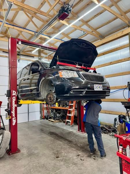 A car is sitting on top of a lift in a garage.