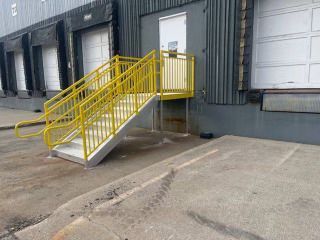 a set of stairs leading up to a building with a yellow railing