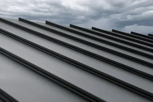 Gray metal roof panels under a cloudy sky