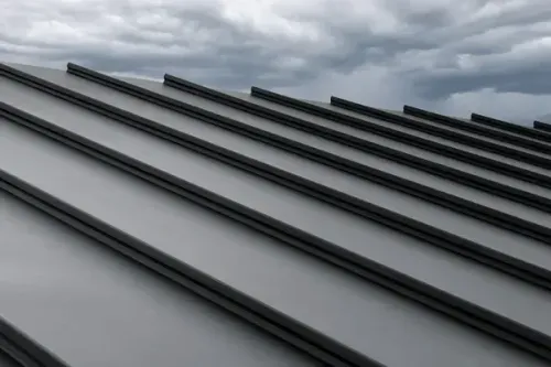 Gray metal roof panels under a cloudy sky