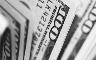 Close-up of U.S. $100 bills fanned together in black and white